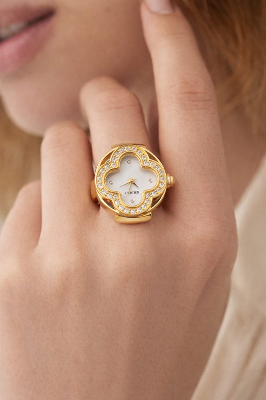 Gold ring with a diamond-studded face worn on a finger