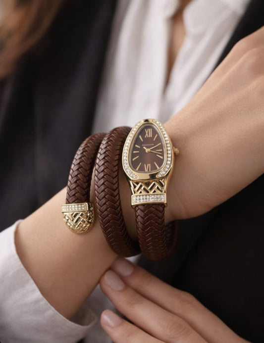Gold watch and brown leather bracelet on a wrist with a blurred background