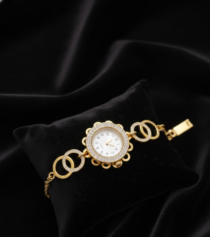 Gold bracelet with a decorative clasp on a black satin background