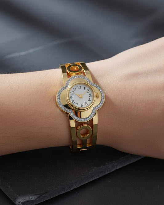 Gold wristwatch with diamond accents on a wrist against a dark background