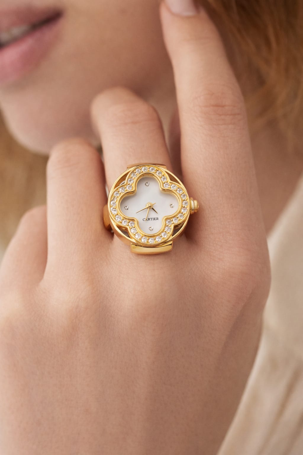 Gold ring with a diamond-studded face worn on a finger