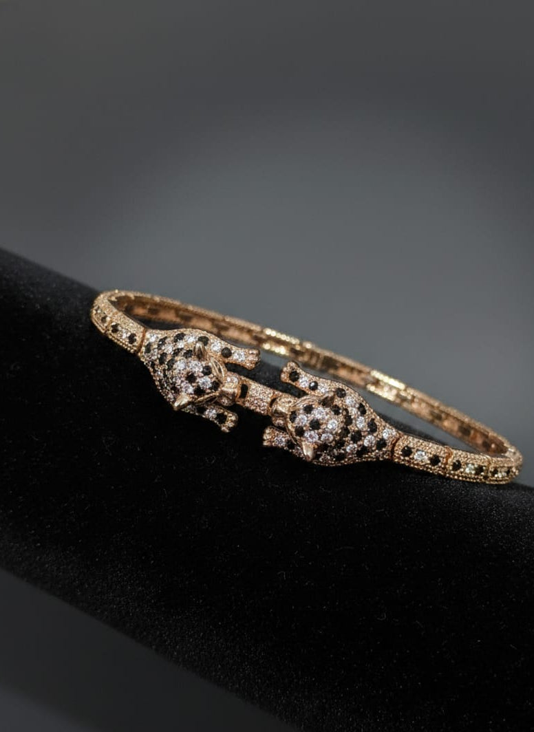 Rose gold bracelet with diamond accents on a black stand