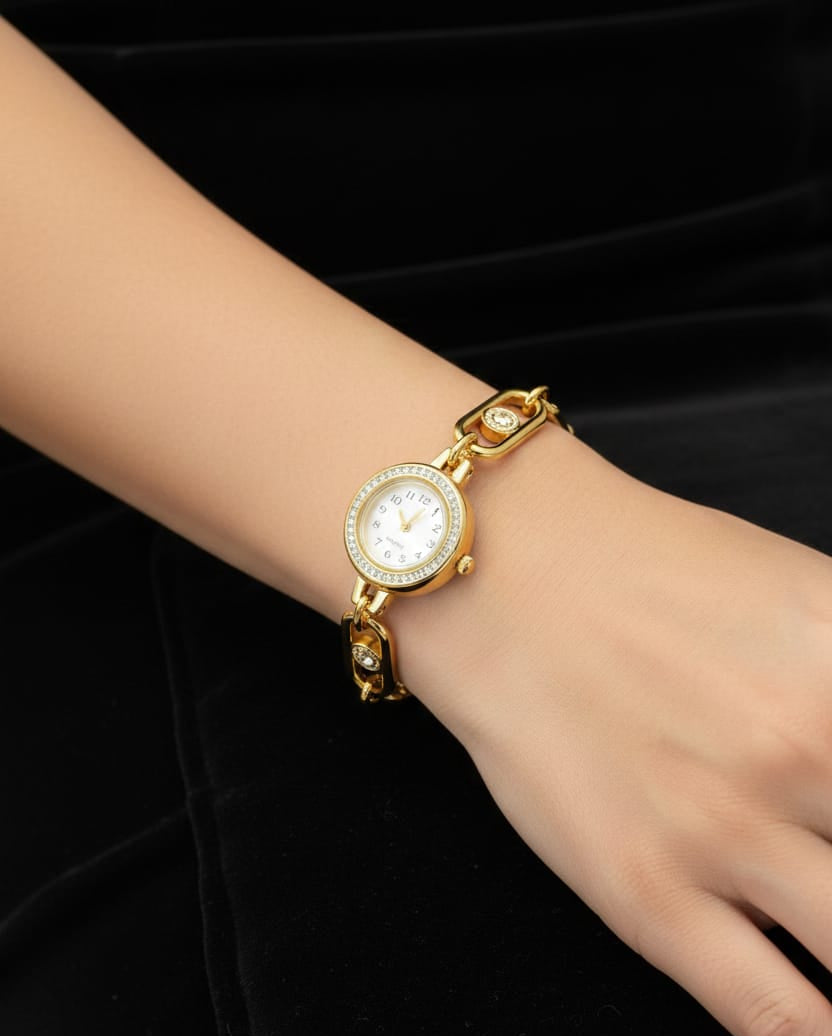Gold wristwatch on a hand against a black background