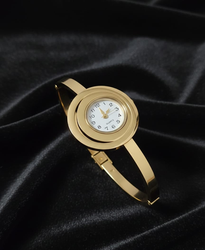 Gold wristwatch on a black satin background