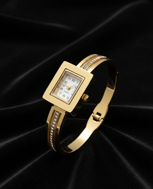 Gold wristwatch with a square face on a black satin background