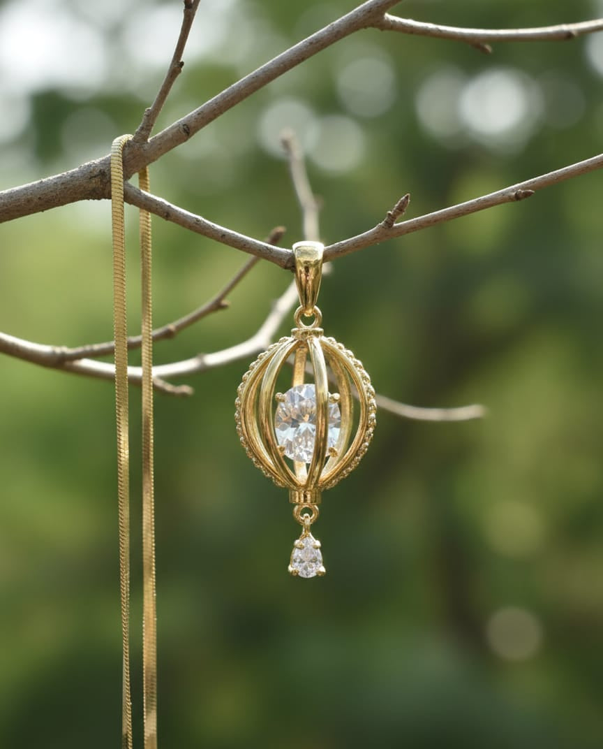 Gold pendant with clear gemstones hanging from a branch with a blurred green background