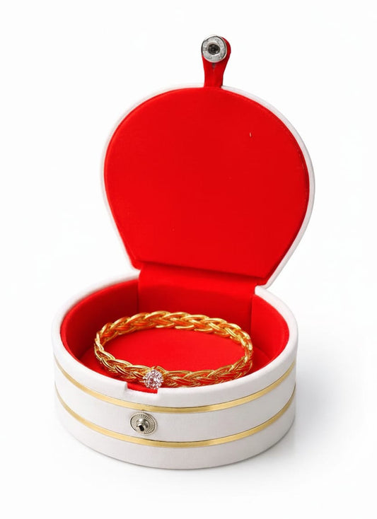 Gold bracelet in a red jewelry box on a white background